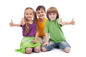 Group of three kids giving thumbs up sign - isolated